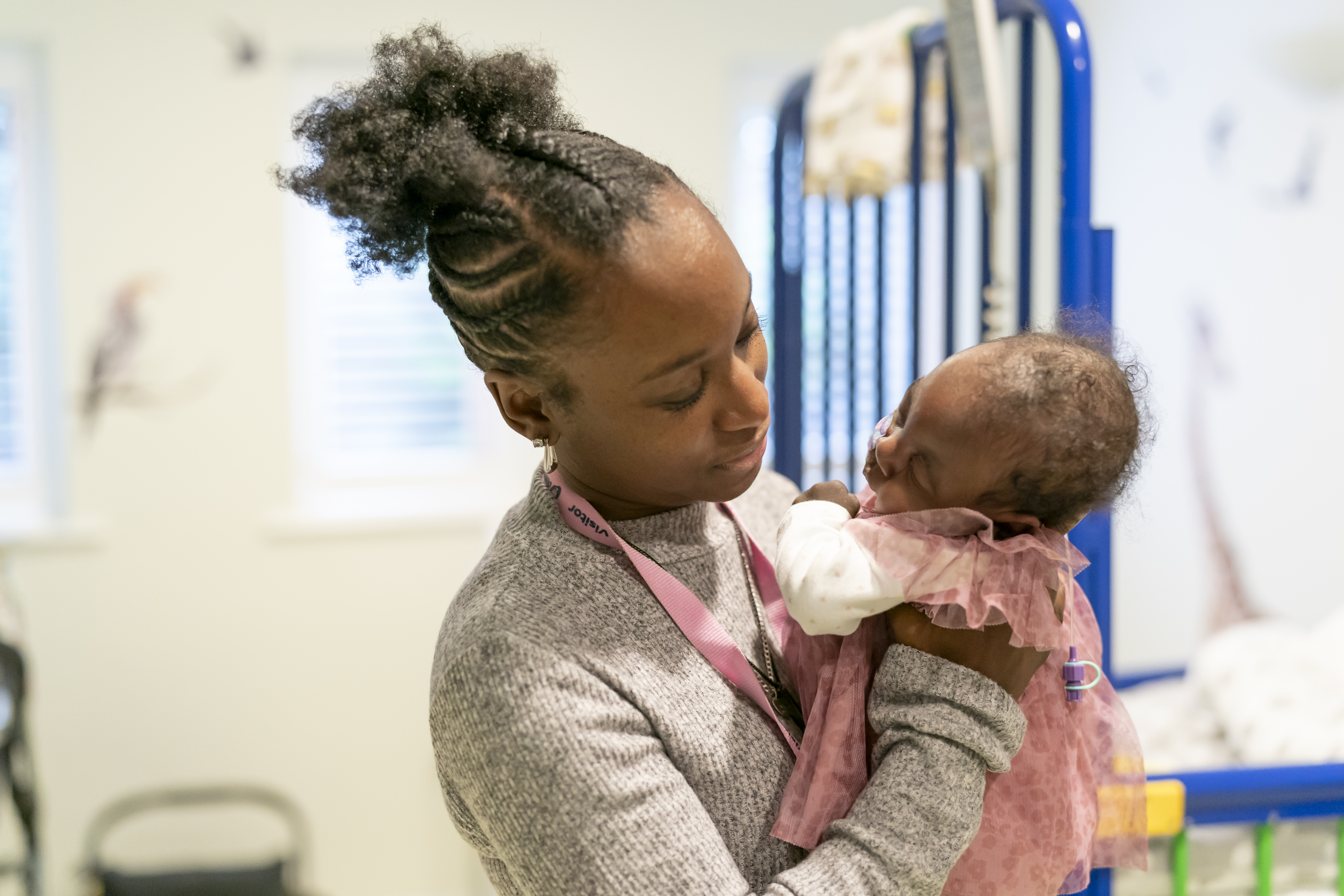 A woman looking towards her baby daughter while holding her