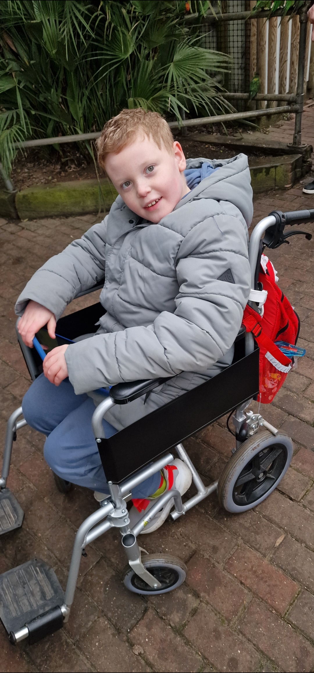 A child in a wheelchair smiling towards the camera