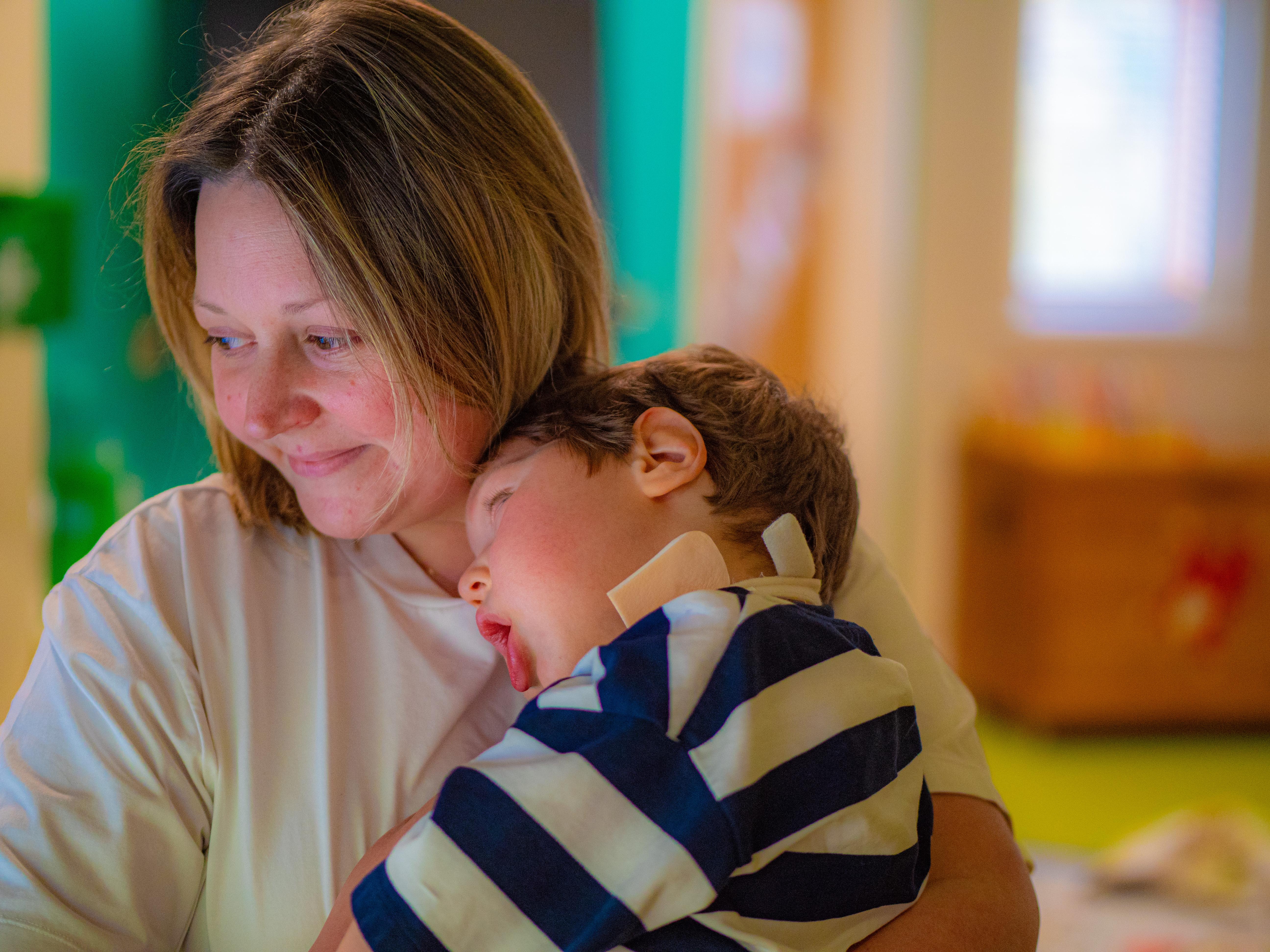 A mother holding her son while smiling