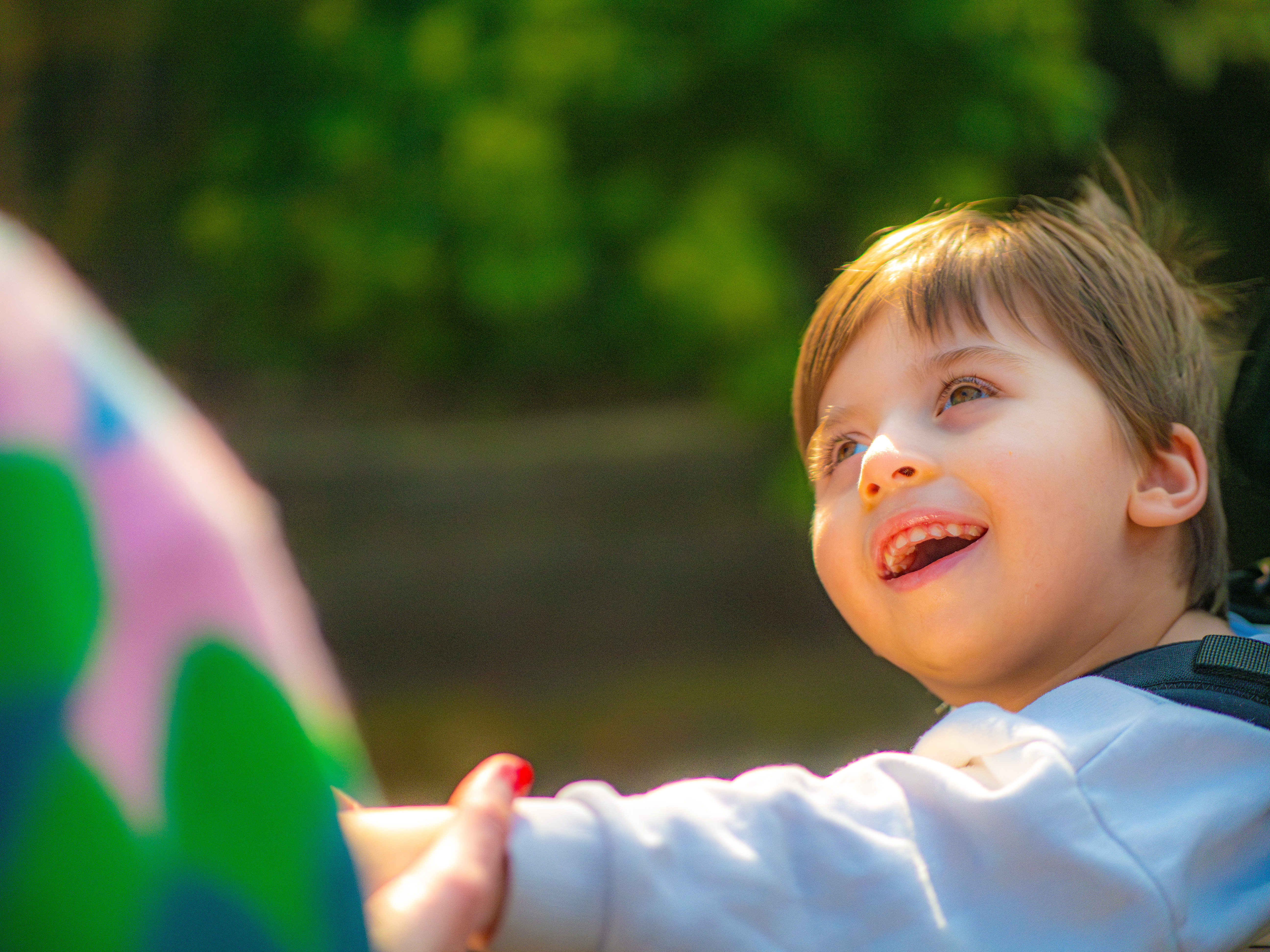 A boy in a white shirt looking up towards his mum smiling