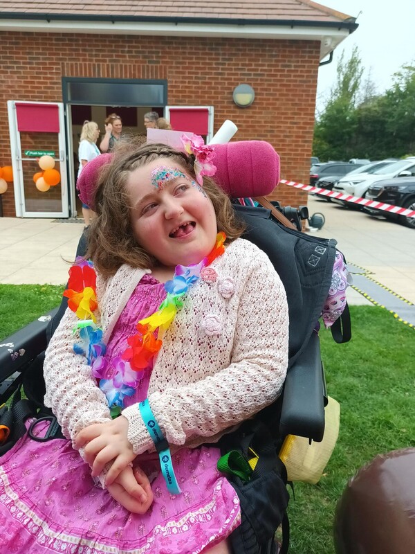 Fia sitting happily at East Sussex Family Fest 2025, dressed in a brightly coloured outfit with matching accessories