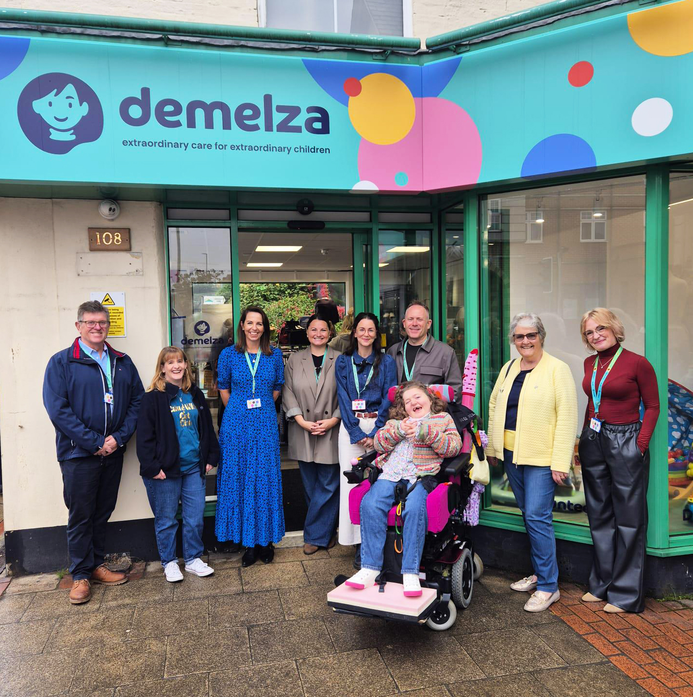 Group photo of people standing outside of a Demelza charity shop