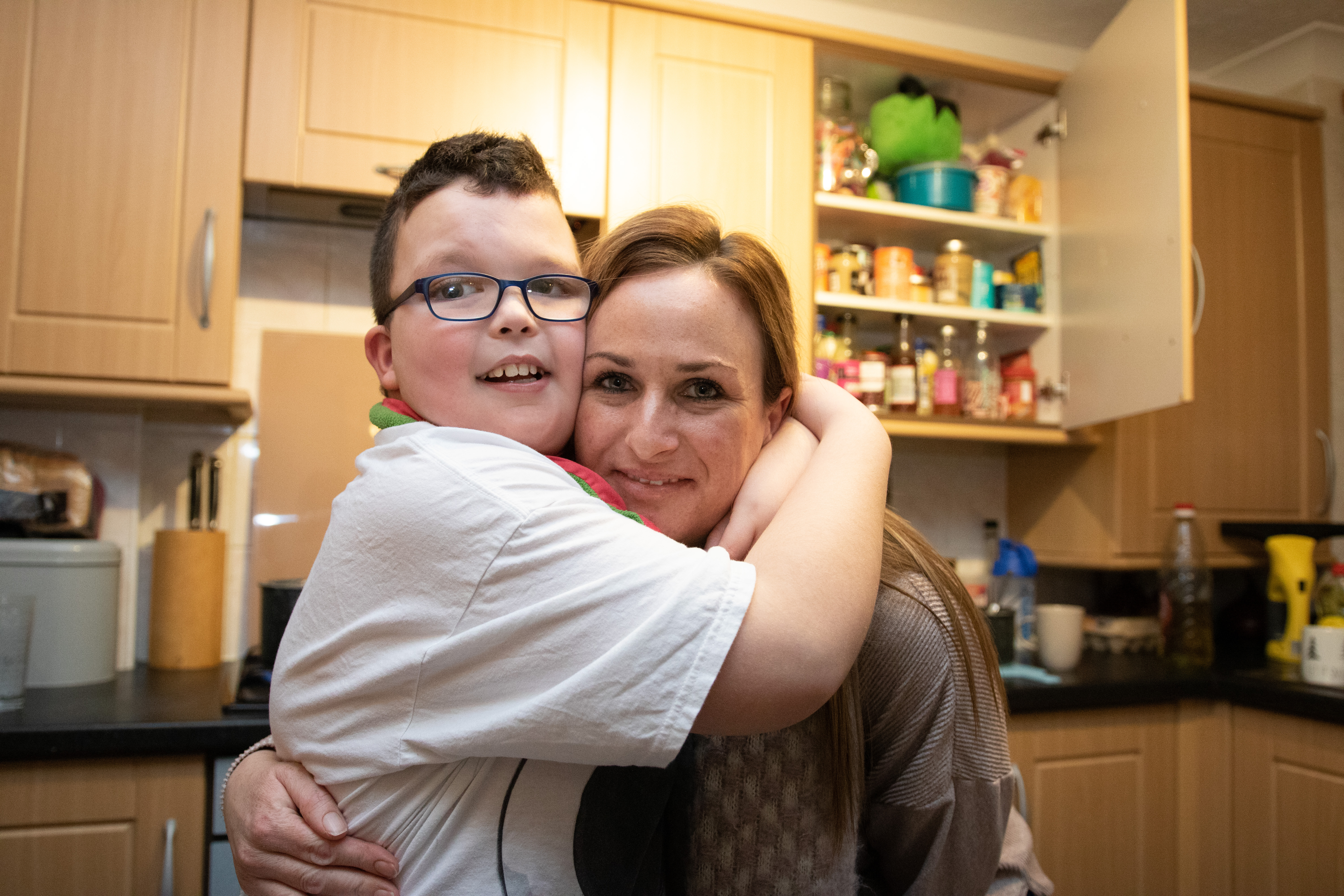 Son and mom hugging in kitchen