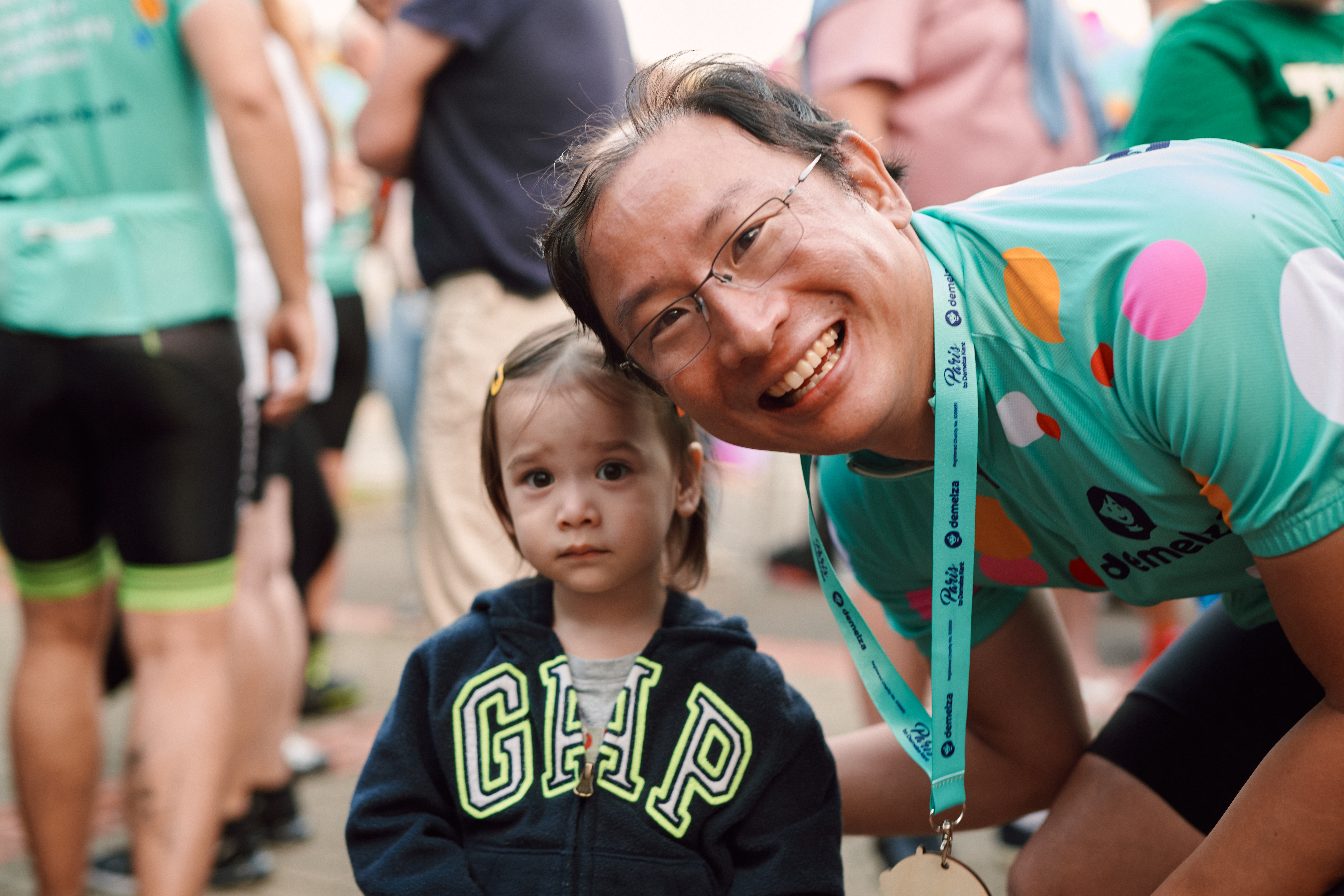 A young girl and an older man with a medal smiling towards the camera