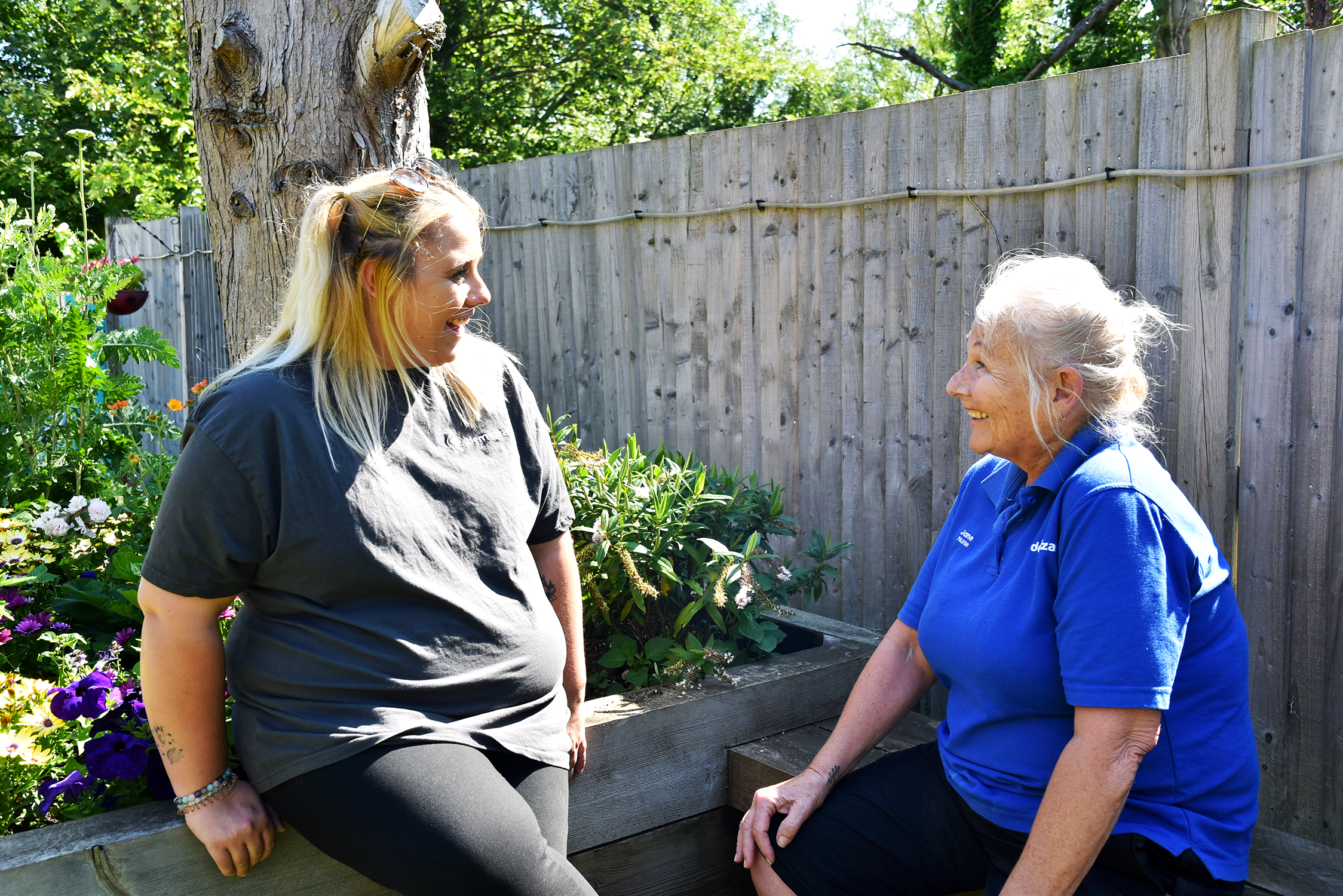 Two women with blonde hair chatting in the garden at East Sussex