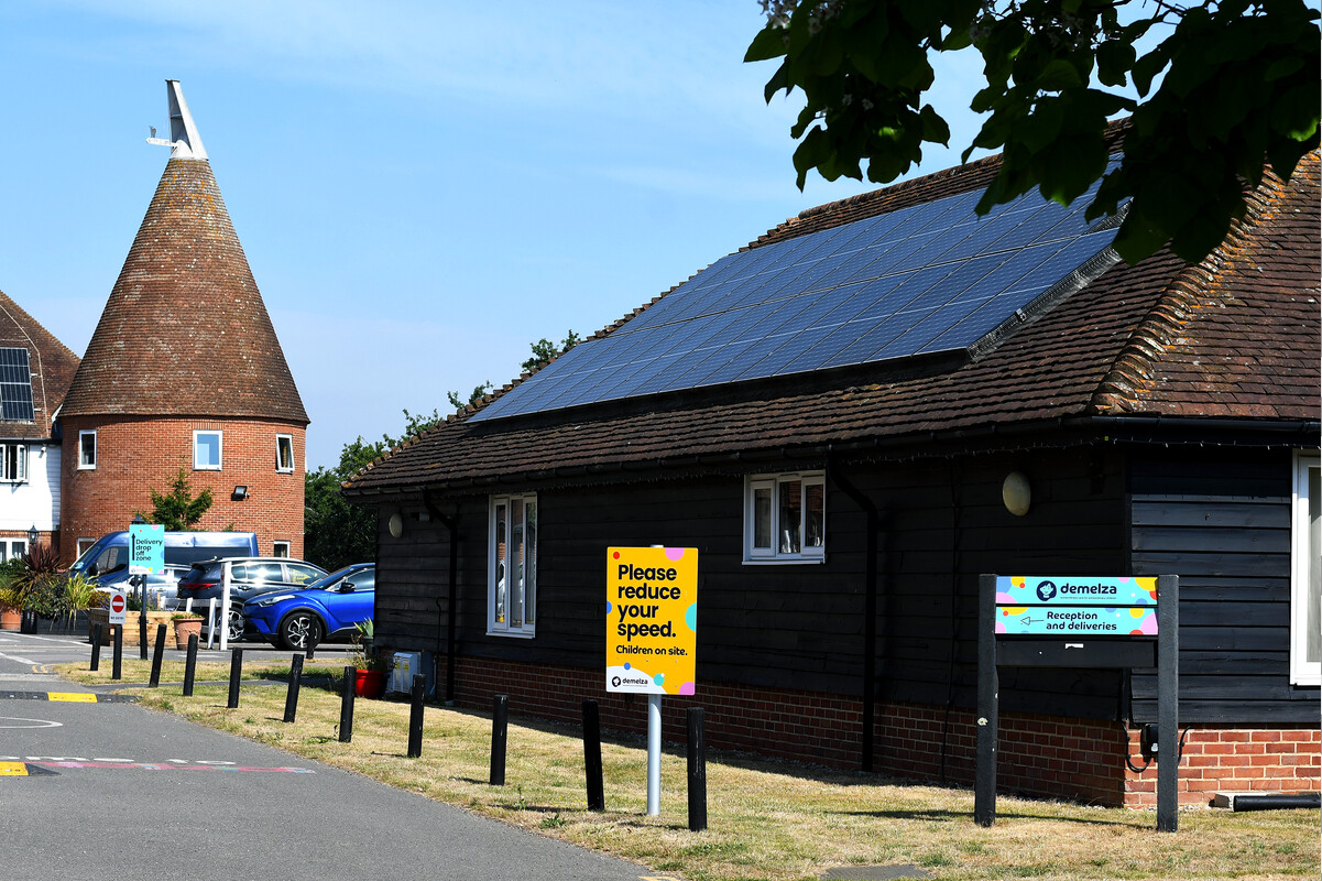 Demelza Kent’s Oast House with visible signage, solar panels on the roof, and adjacent car park under a bright sky