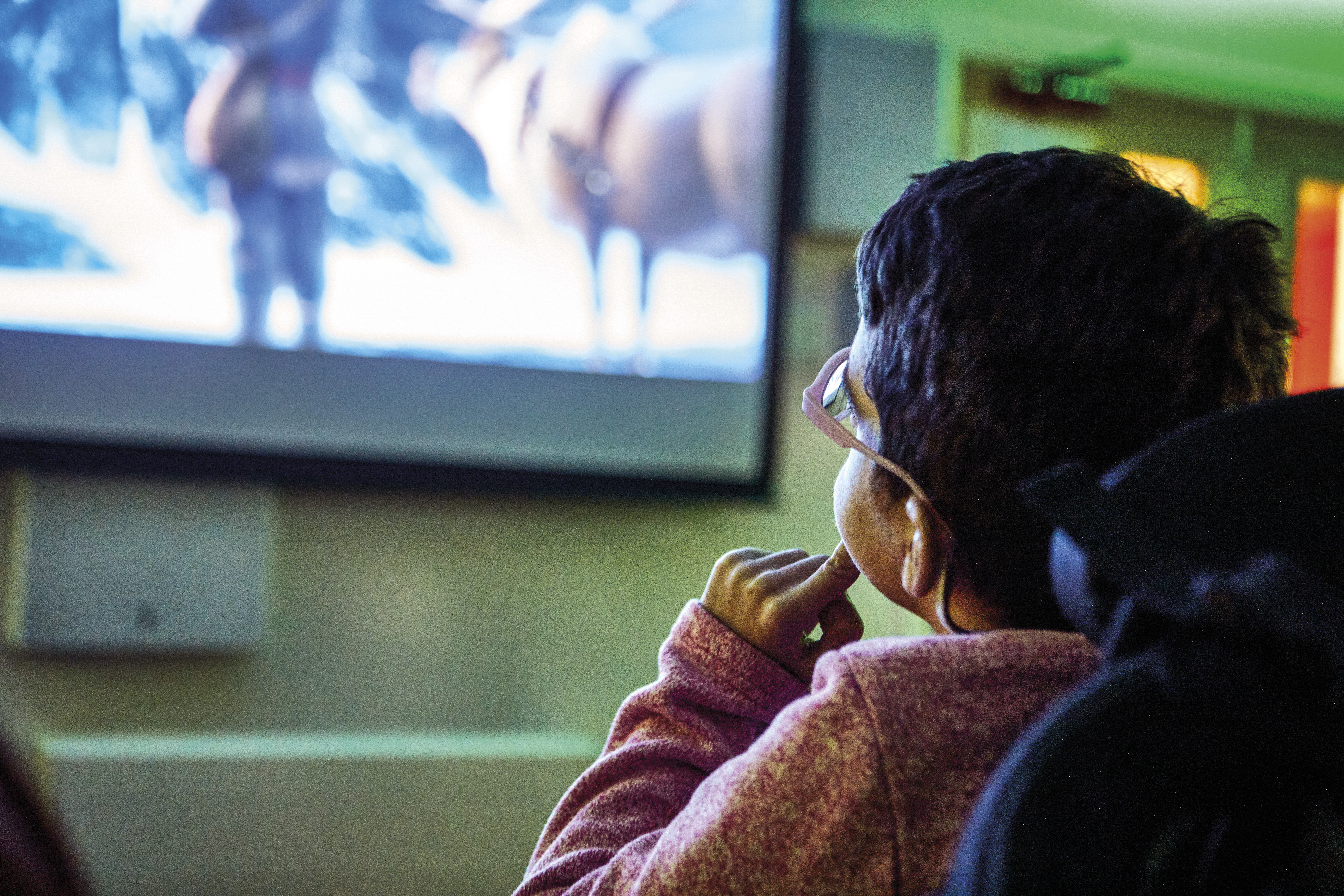 Child in the cinema room at Demelza watching the screen