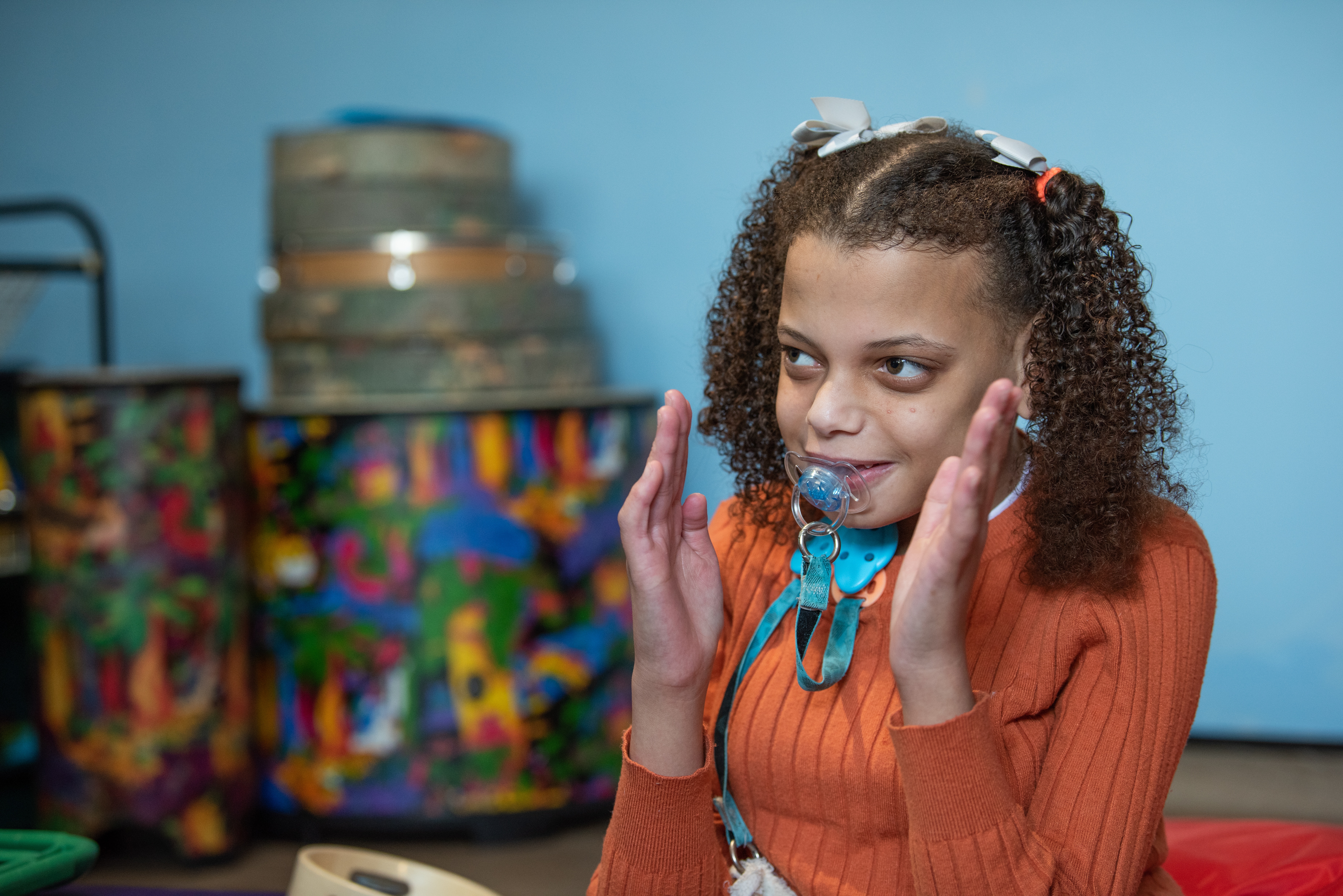 Child smiling and clapping in therapy