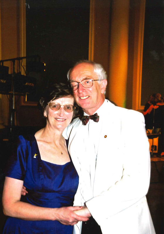 Demelza founders Derek and Jennifer Phillips stand side by side at a black tie event, smiling; Jennifer in blue, Derek in white jacket.