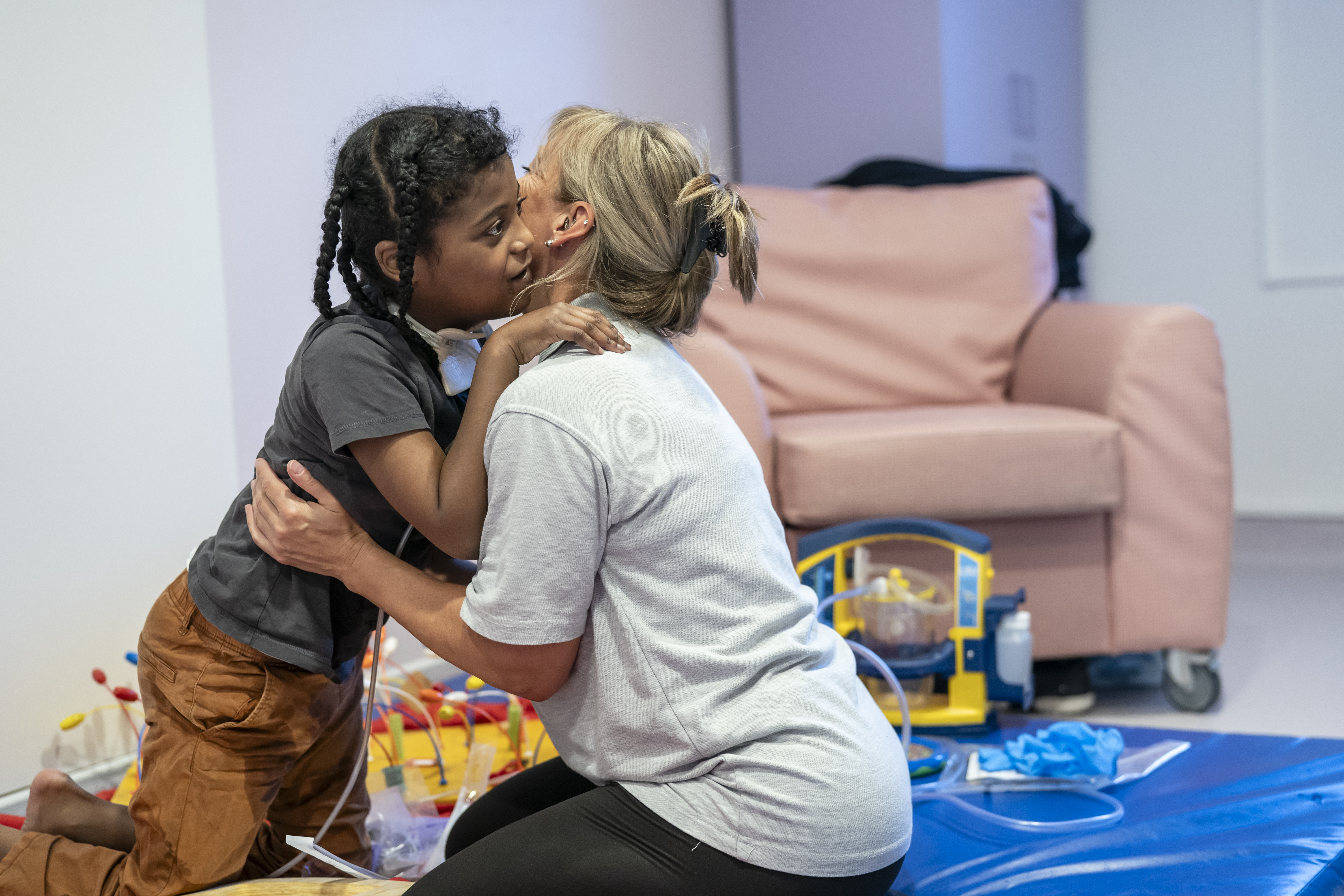 A child hugging a Demelza nurse 
