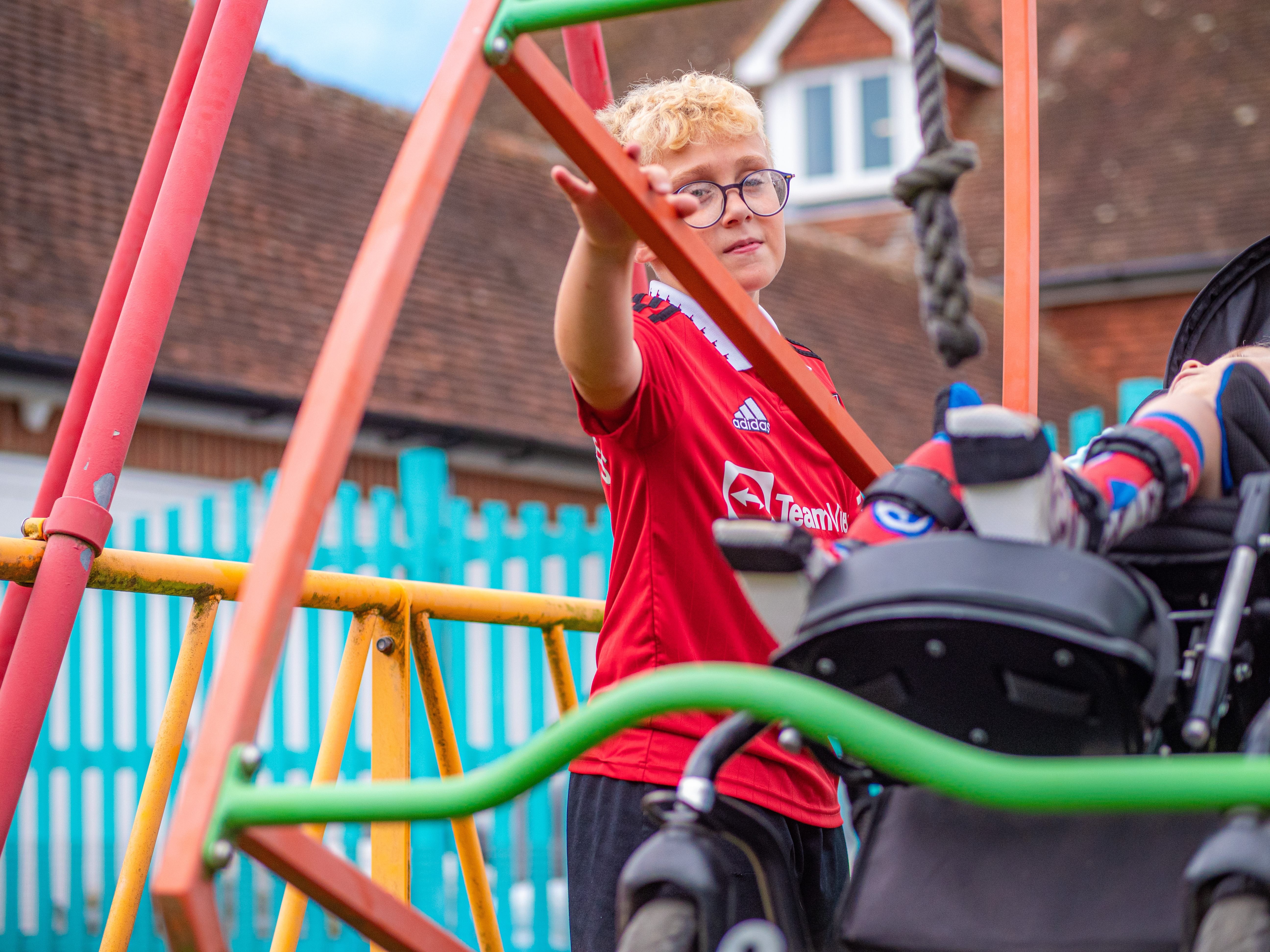 Young person standing by the Demelza swing in the park