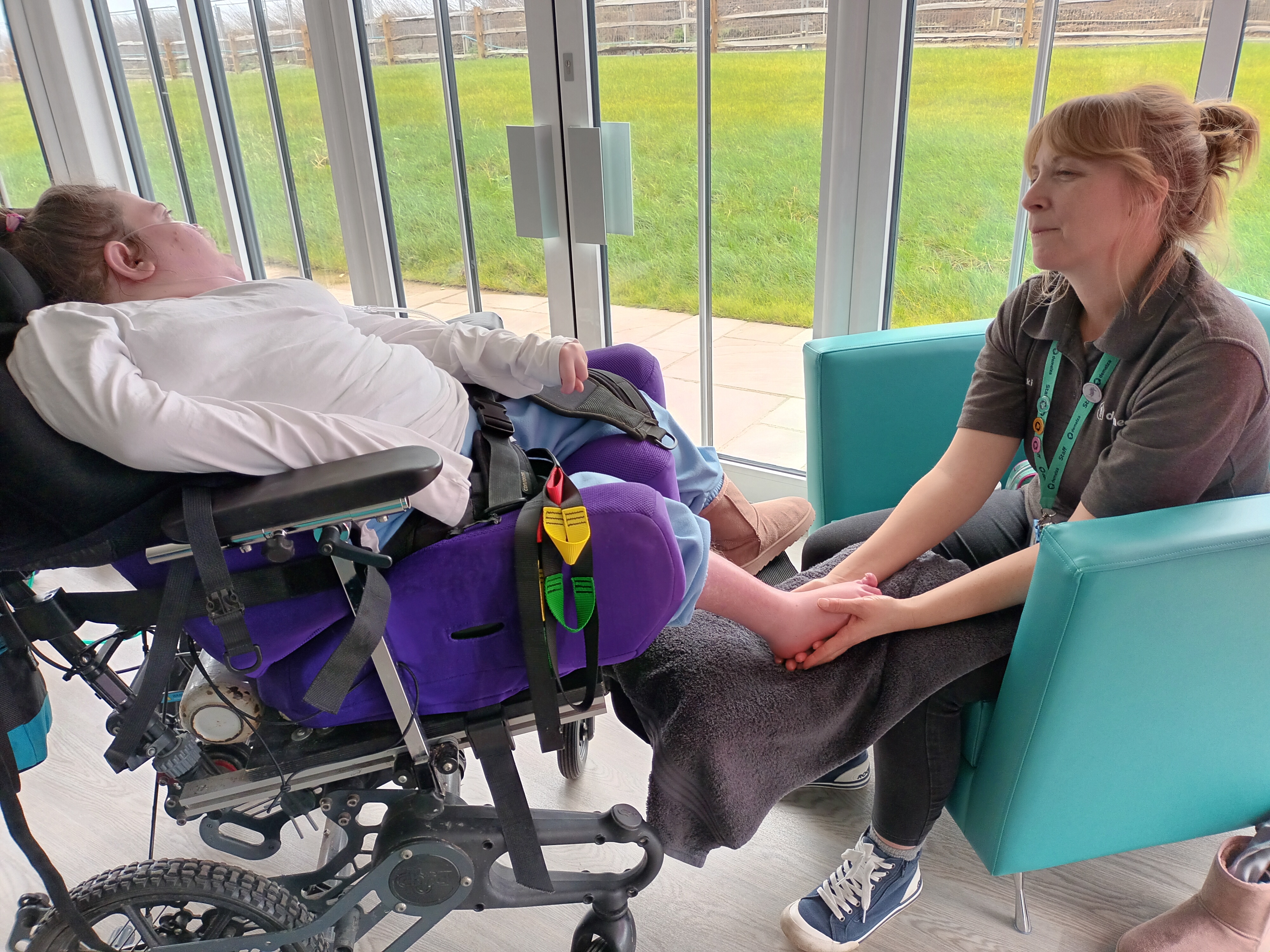 Young person receiving reflexology from staff
