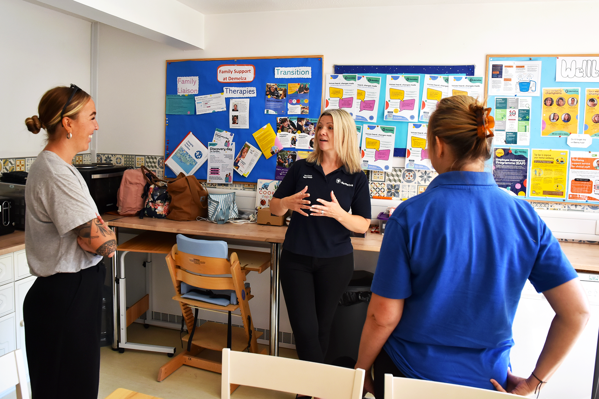 Three staff members at East Sussex chatting in the kitchen